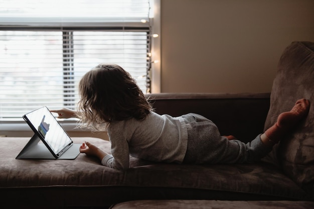 Vrouw met een laptop terwijl ze thuis op de bank zit