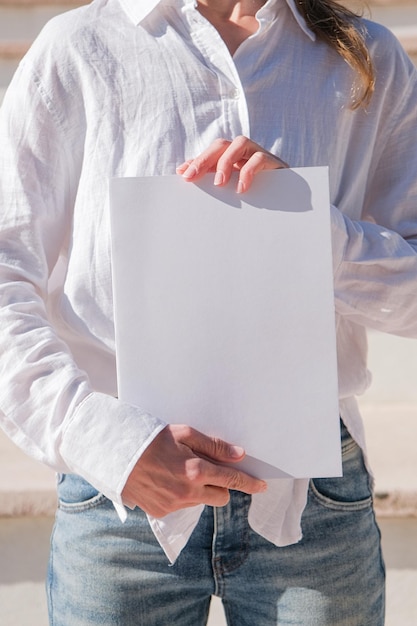 vrouw met een leeg wit boek buiten op de trap achtergrond boek mockup