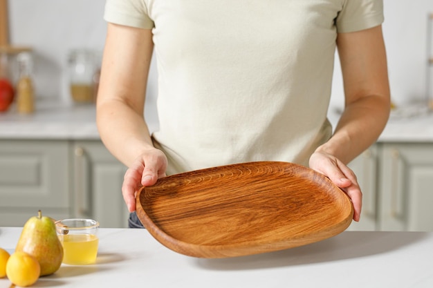 Vrouw met een lege houten schaal met behulp van houten ovale eiken plaat bord lade gezonde voeding