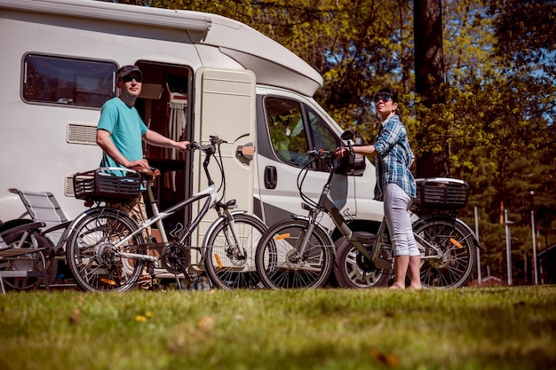 Vrouw met een man op elektrische fiets die op de camping rust. familie vakantie reizen, vakantie reis in camper rv, caravan auto vakantie.