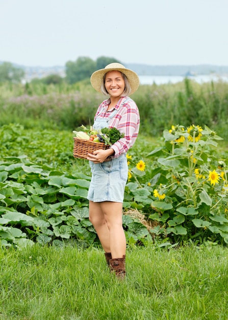 Vrouw met een mand vol oogst biologische groenten en wortel op biologische biologische boerderij. Herfst Plantaardige Oogst.