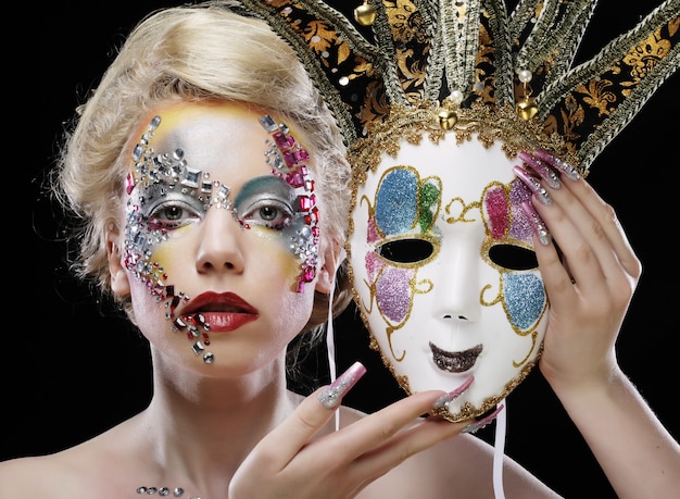 Vrouw met een masker met artistieke make-up