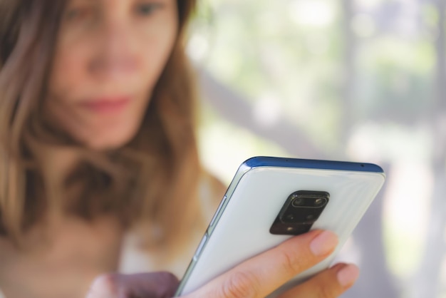 Vrouw met een mobiele telefoon in haar handen close-up