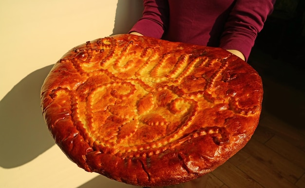 Vrouw met een mooi versierd groot Gata lekker zoet gevuld Armeens traditioneel brood