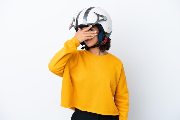 Vrouw met een motorhelm die de ogen bedekt met de handen en glimlacht