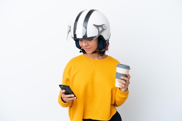 Vrouw met een motorhelm met koffie om mee te nemen en een mobiel