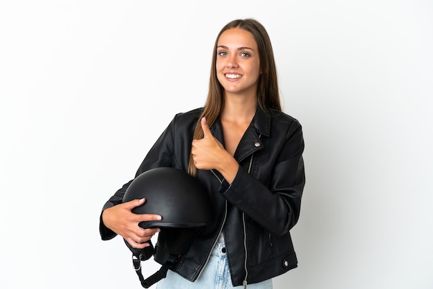 Vrouw met een motorhelm over geïsoleerde witte achtergrond die een duim omhoog gebaar geeft