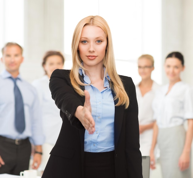 Foto vrouw met een open hand klaar voor handdruk op kantoor