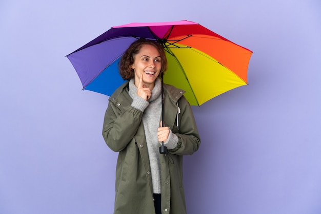 vrouw met een paraplu poseren geïsoleerd tegen de blinde muur