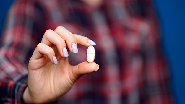 Foto vrouw met een pil in haar hand