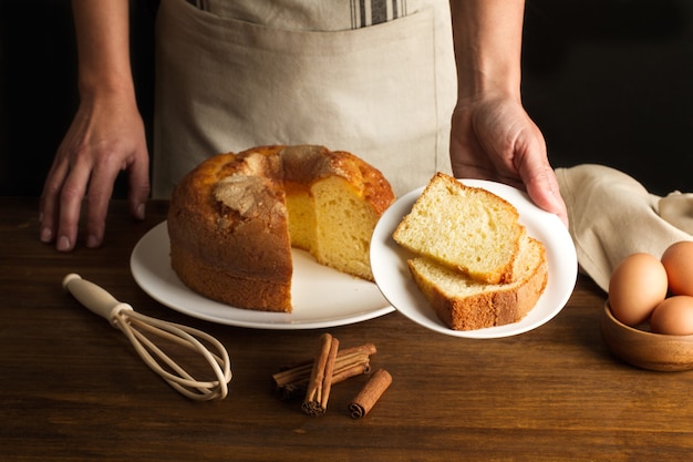 Vrouw met een plaat met vanille cake plakjes op een houten tafel