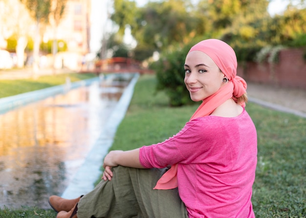 Vrouw met een roze sjaal op haar hoofd in het park