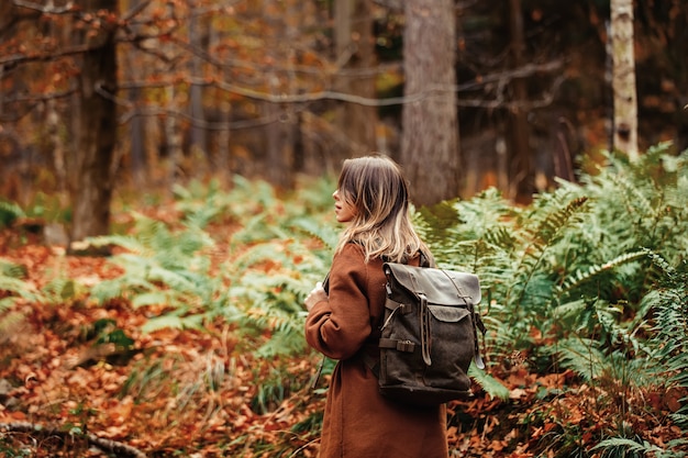 vrouw met een rugzak in het herfstbos