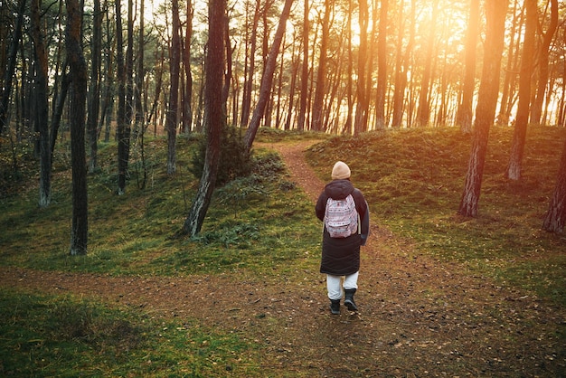 Vrouw met een rugzak wandelen in het park Concept van alleen reizen en buitenshuis ontdekken Persoon in het bos