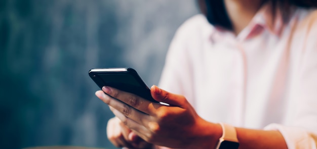 Vrouw met een smartphone, mock up van leeg scherm. gebruik mobiele telefoon op café.