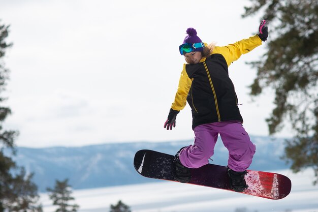 Vrouw met een snowboard springt