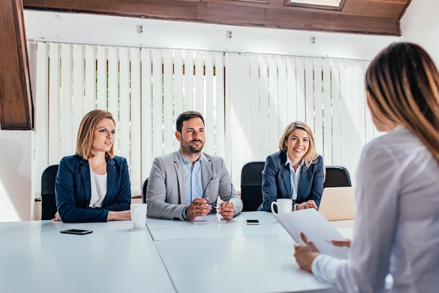 Vrouw met een sollicitatiegesprek met HR-specialisten.