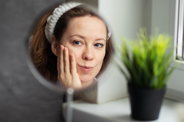 Foto vrouw met een spiegel met gezichtscreem huid hydraterende zorg en gezondheid