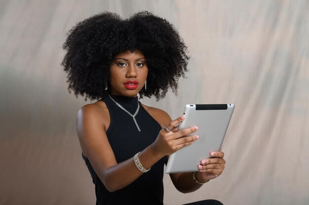 Vrouw met een tablet die naar de camera kijkt zwarte vrouw