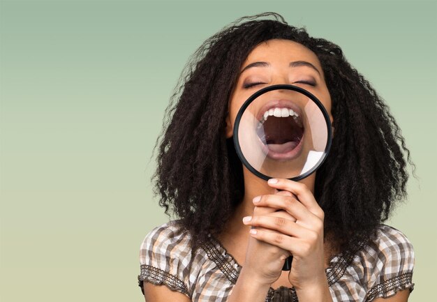 Foto vrouw met een vergrootglas voor haar mond