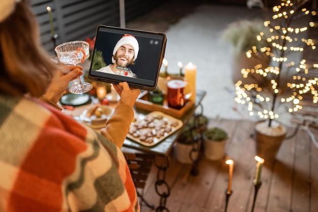 Vrouw met een videogesprek met een vriend tijdens een nieuwjaarsviering. Concept van videocommunicatie tijdens zelfisolatie en quarantaine voor de feestdagen