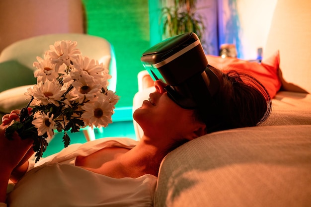 Vrouw met een virtual reality-bril met bloemen in haar handen op virtuele valentijnsdag