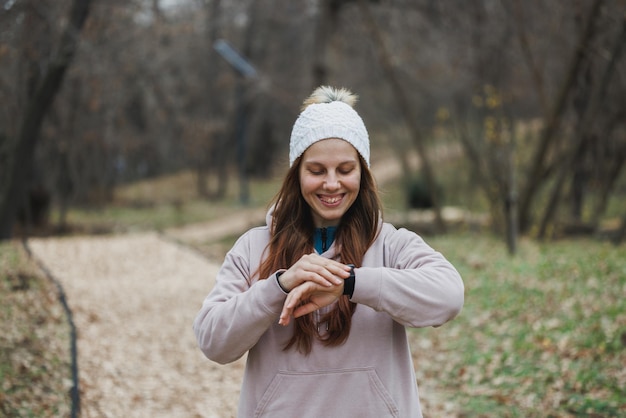 Vrouw met een witte hoed die door het bos loopt