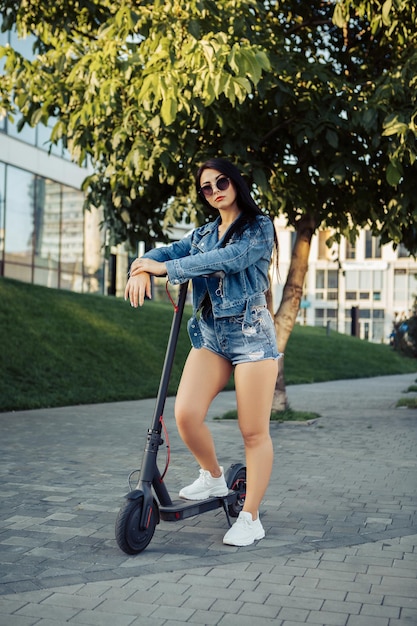 Vrouw met elektrische scooter op straat in de stad