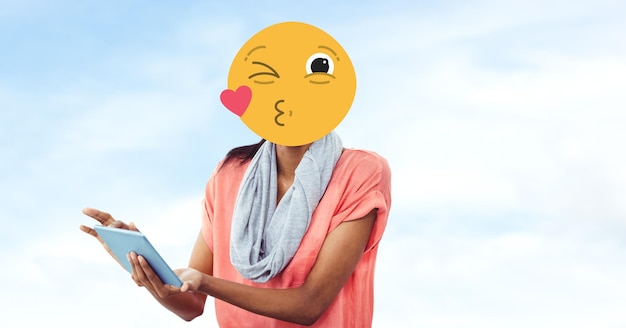 Vrouw met emoji over gezicht met behulp van tablet-pc