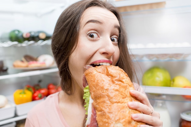 Vrouw met eten in de buurt van koelkast