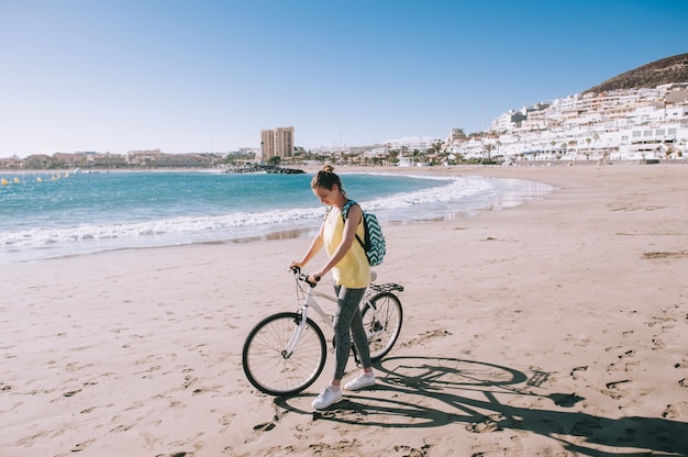 Vrouw met fiets in het strand