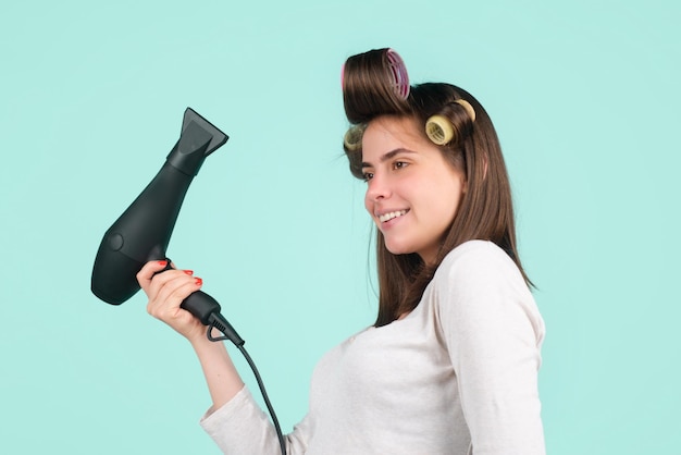 Vrouw met föhn geïsoleerd in studio mooi meisje met steil haar drogen haar met professi