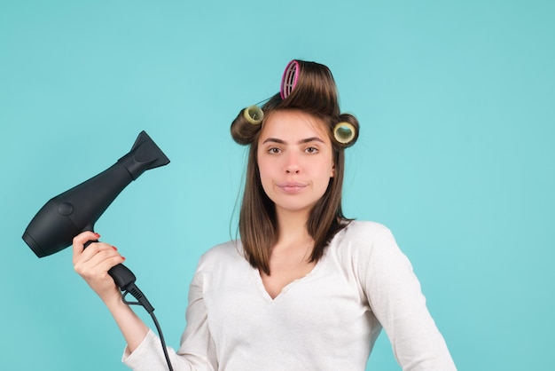 Vrouw met föhn mooi meisje met steil haar drogend haar met professionele haardroger