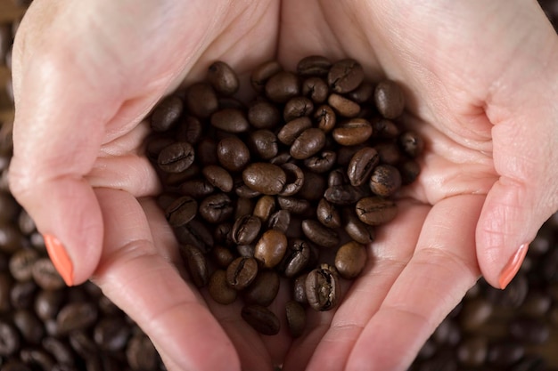 Vrouw met gebrande koffiebonen in haar handen