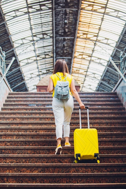 Vrouw met gele tas gaat via de trap naar het treinstation