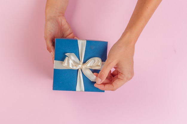 Vrouw met geschenkdoos op roze