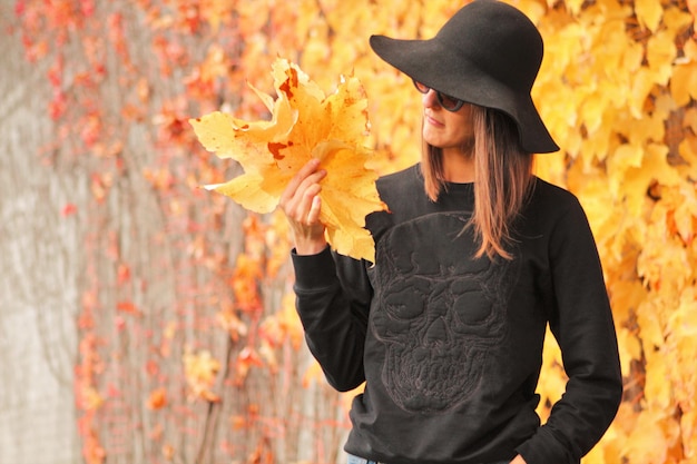 Foto vrouw met gevallen herfstbladeren