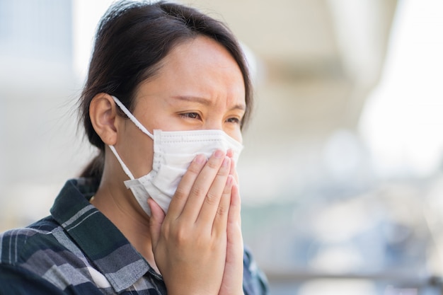 Vrouw met gezichtsmasker beschermt filter tegen luchtvervuiling (pm2.5)