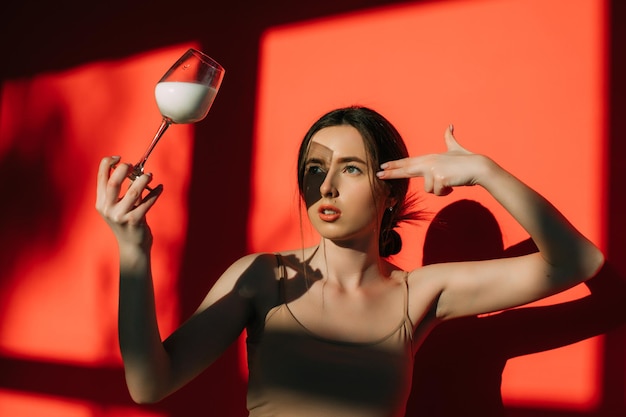 Vrouw met glas melk op rode achtergrond. Creatieve foto