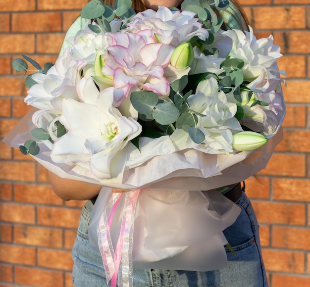 Vrouw met groot boeket van mooie witte lelies