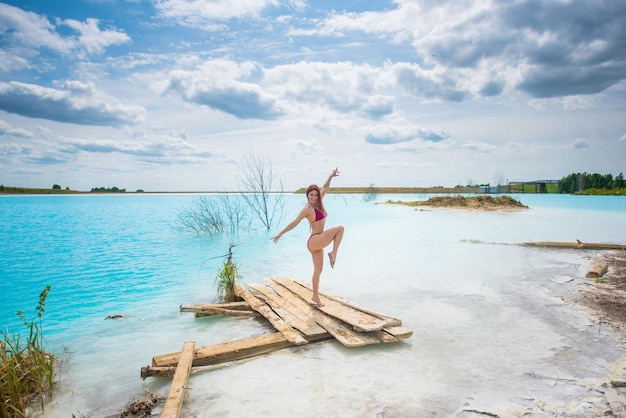 Foto vrouw met haar armen omhoog op de kust tegen de lucht