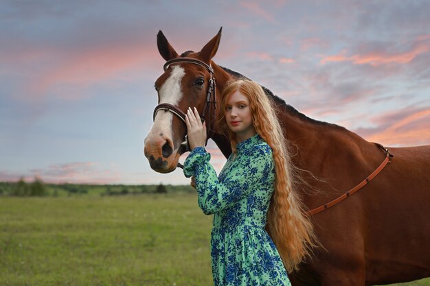 Vrouw met haar paard bij zonsondergang, herfst