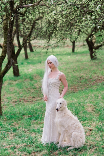 Vrouw met haar Russische wolfshond hond in de tuin