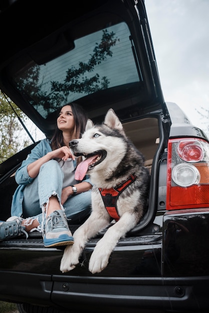 Foto vrouw met haar schattige husky hond reizen met de auto