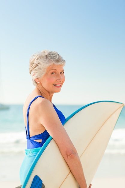 Vrouw met haar surfplank op het strand