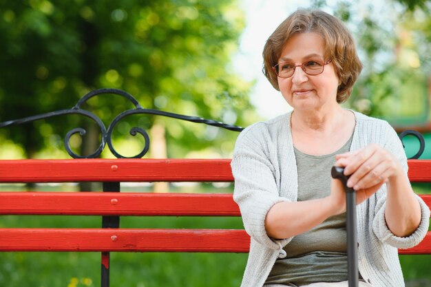 Vrouw met haar wandelstok in het park