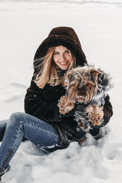 Vrouw met haar yorkshire terrier ziet er erg gelukkig uit.