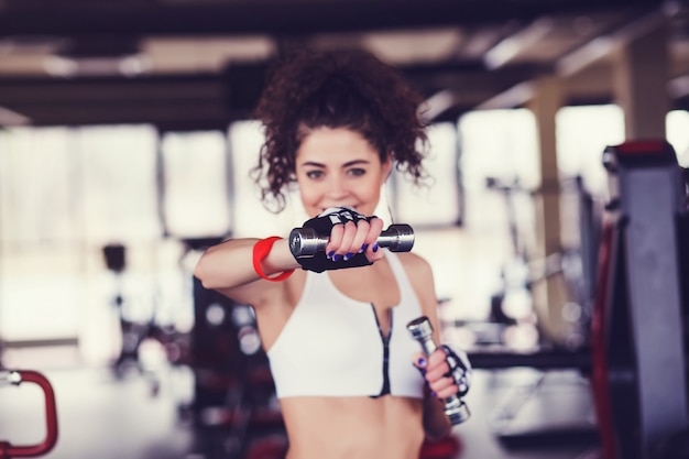 Vrouw met halters in de sportschool