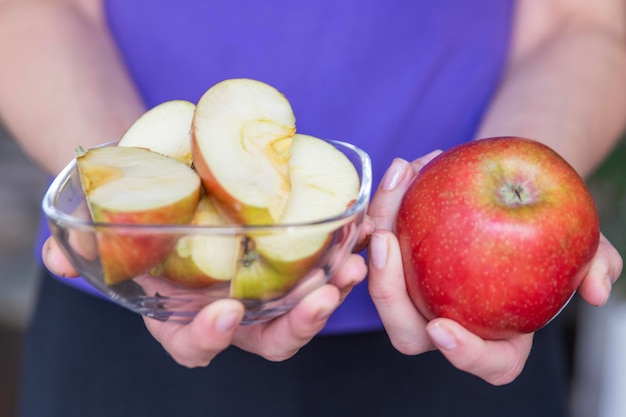 Vrouw met halven en hele appels in close-up een snelle snack in de vorm van een appel