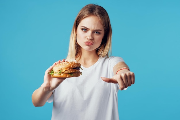 Vrouw met hamburger fastfood levering snack leuke blauwe achtergrond foto van hoge kwaliteit